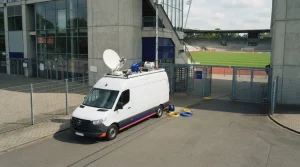 Übertragungswagen am Rand eines beleuchteten Fußballstadions